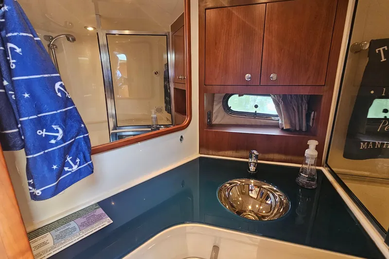 Slide: The Image of Luxurious bathroom in 2006 Chris-Craft Corsair 36 yacht with wood cabinets and nautical decor. - 25