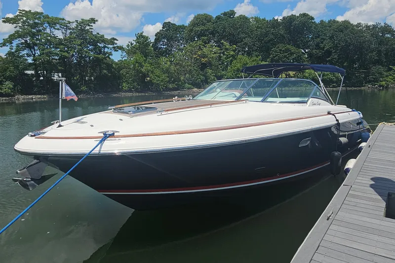 Slide: The Image of 2006 Chris-Craft Corsair 36 boat docked on a sunny day with lush greenery. - 5