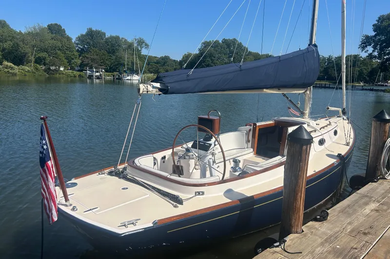 Slide: The Image of 2008 Alerion Express 33 sailboat docked on a calm river, surrounded by trees. - 10