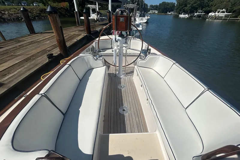 Slide: The Image of 2008 Alerion Express 33 sailboat with white seating and wooden deck, docked by a pier. - 11