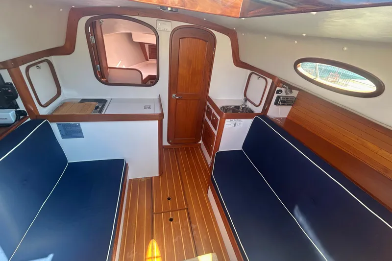 Slide: The Image of Interior of 2008 Alerion Express 33 sailboat with wooden finishes and blue seating. - 12