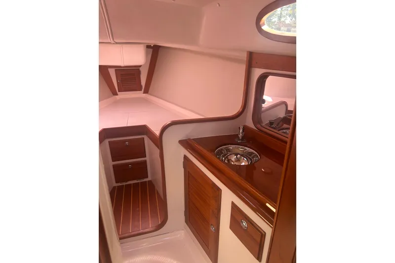 Slide: The Image of 2008 Alerion Express 33 yacht interior with wood finish and compact sink area. - 14