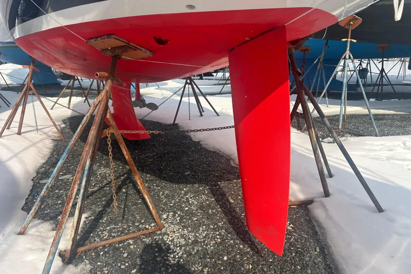 Slide: The Image of 2008 Alerion Express 33 sailboat keel on stands in snowy boatyard. - 23