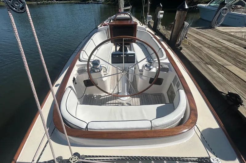 Slide: The Image of 2008 Alerion Express 33 sailboat cockpit with wooden accents and steering wheel at dock. - 9