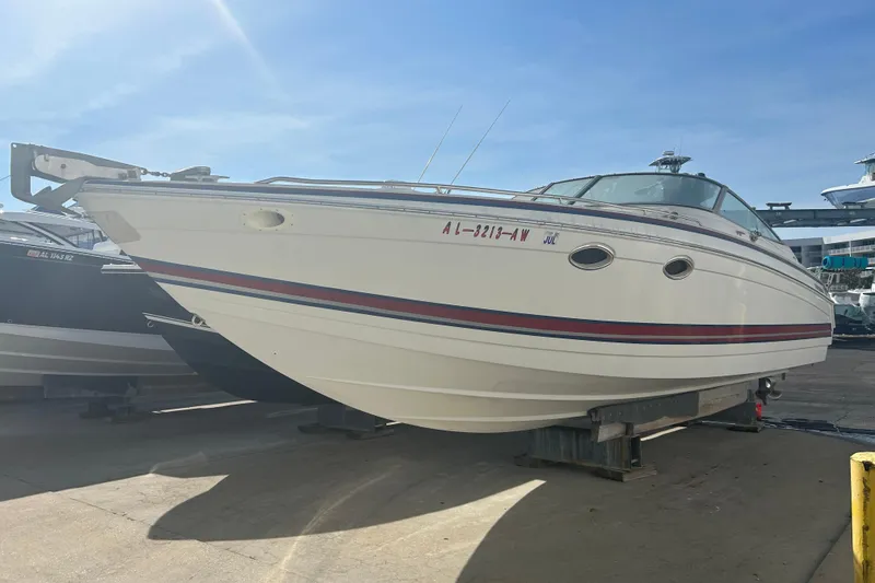 The Image of 1998 Formula 330 Sun Sport boat on dry dock under clear blue sky. - 0