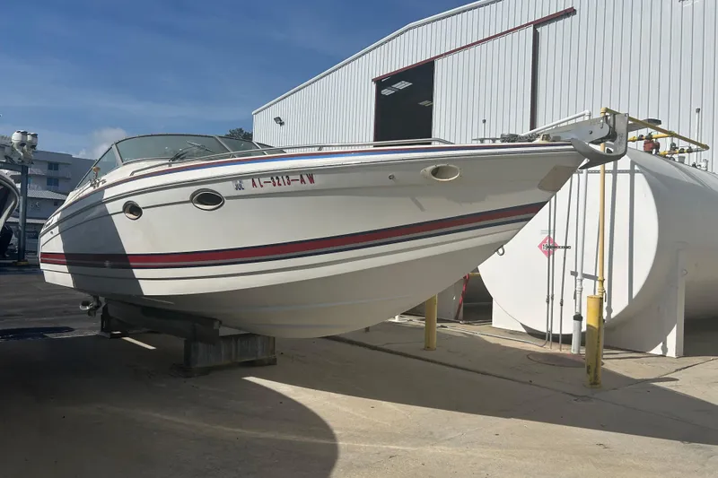 Slide: The Image of 1998 Formula 330 Sun Sport boat on dry dock near a storage facility. - 3