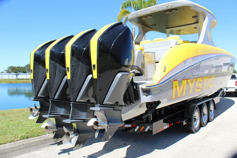 Slide: The Image of 2021 Mystic M4200 boat with four powerful outboard engines on a trailer. - 14
