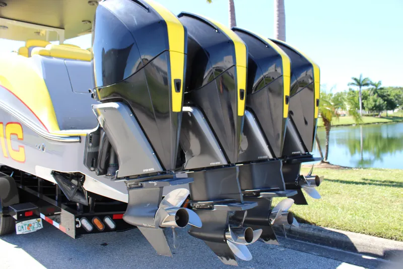 Slide: The Image of 2021 Mystic M4200 boat with four powerful outboard engines, parked near a scenic lake. - 17