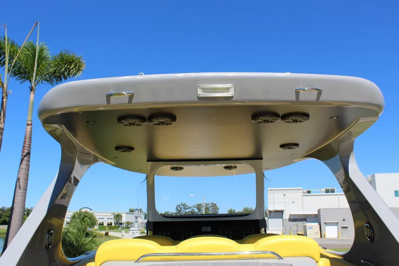 Slide: The Image of 2021 Mystic M4200 boat with sleek design, yellow seating, and modern canopy speakers. - 25