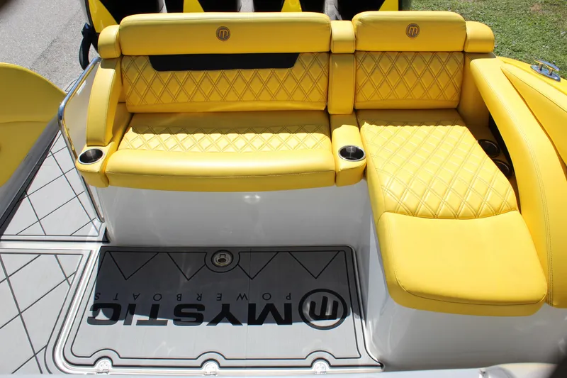 Slide: The Image of Yellow quilted seating on 2021 Mystic M4200 boat, featuring cup holders and branded flooring. - 27