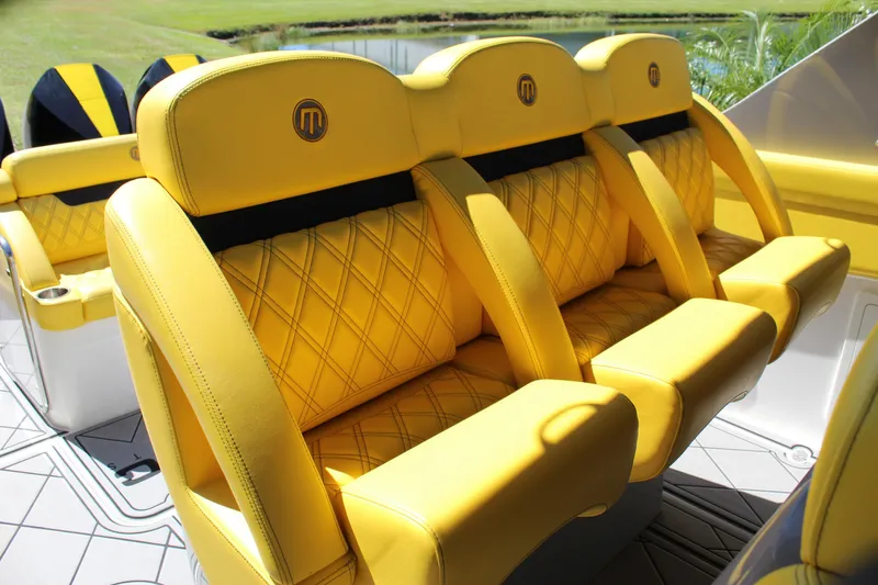 Slide: The Image of Yellow leather seats in a 2021 Mystic M4200 boat, featuring diamond stitching and logo detailing. - 31