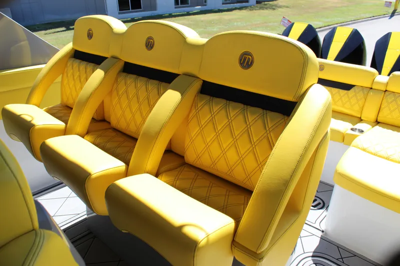 Slide: The Image of Yellow leather seats in a 2021 Mystic M4200 boat, featuring diamond stitching and logo. - 32