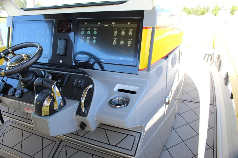 Slide: The Image of Dashboard of a 2021 Mystic M4200 boat with dual touchscreens and steering wheel. - 43