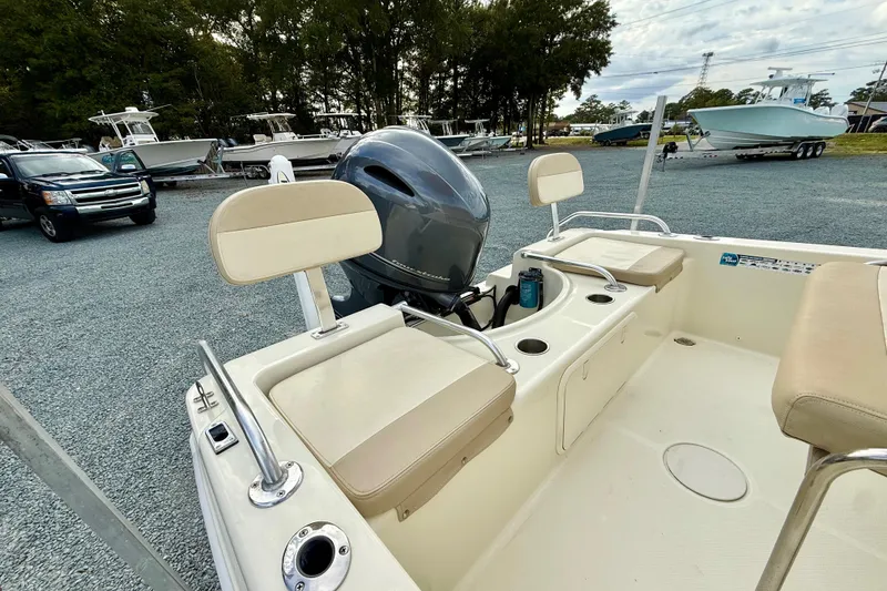 Slide: The Image of 2016 Release 180 CC boat interior with seating and motor, parked on gravel lot. - 11