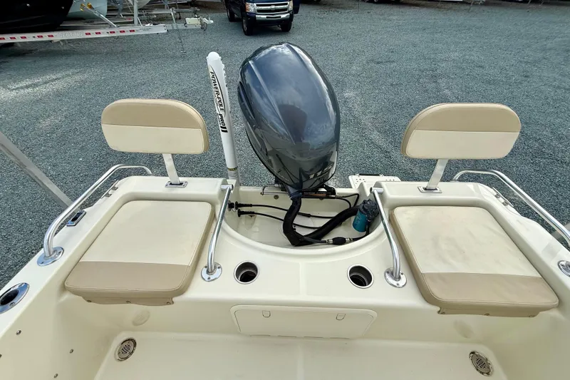 Slide: The Image of 2016 Release 180 CC boat with dual seats and outboard motor in a gravel lot. - 15