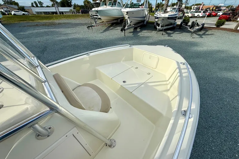 Slide: The Image of 2016 Release 180 CC boat interior with seating and storage, parked on gravel. - 21