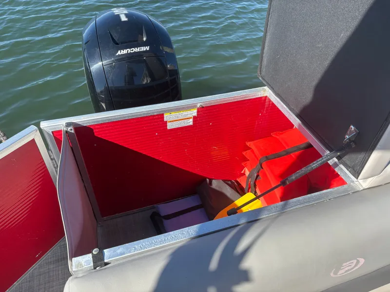 Slide: The Image of Open storage compartment on 2022 Princecraft 23 Vectra boat with life jackets and Mercury engine. - 12