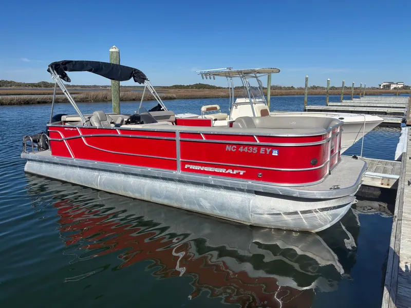 Slide: The Image of 2022 Princecraft 23 Vectra pontoon boat docked on calm water. - 14