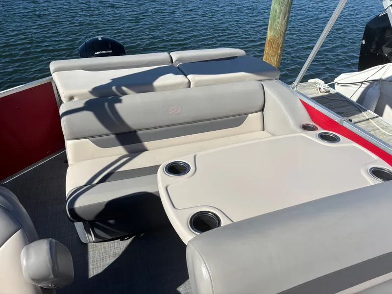 Slide: The Image of 2022 Princecraft 23 Vectra boat interior with cushioned seating and cup holders on a sunny day. - 5