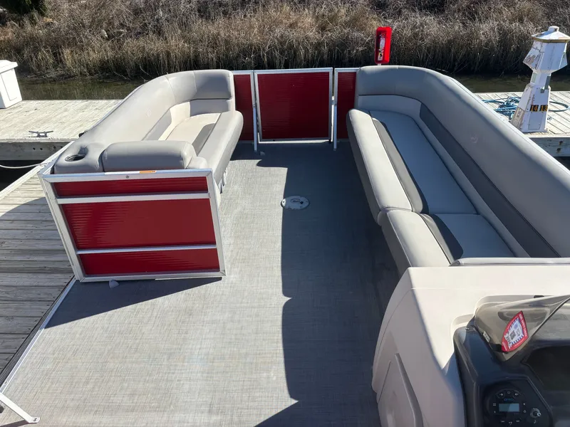 Slide: The Image of 2022 Princecraft 23 Vectra pontoon boat with gray seating and red paneling, docked. - 8