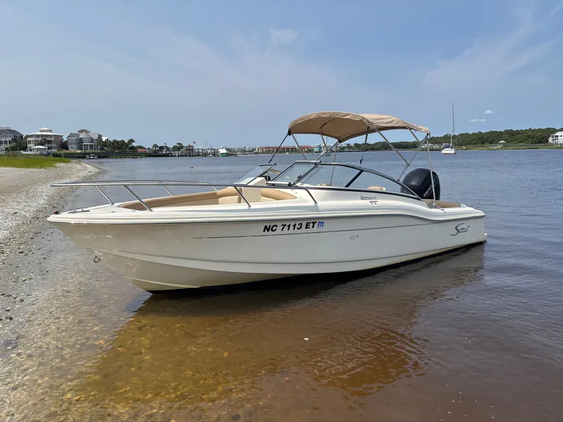 The Image of 2022 Scout 210 Dorado boat docked on a calm shoreline. - 0