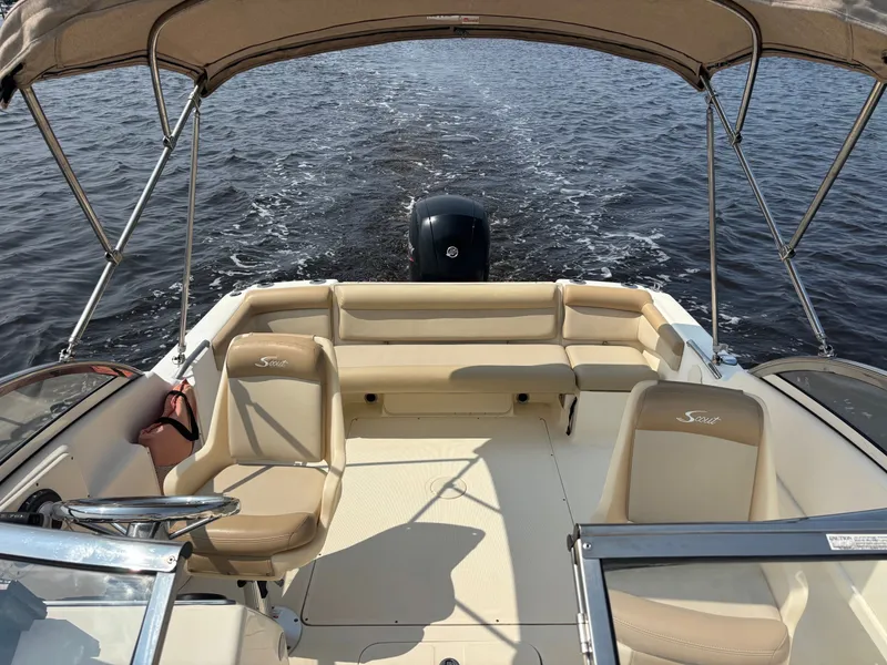 Slide: The Image of 2022 Scout 210 Dorado boat interior with seating and canopy on open water. - 14