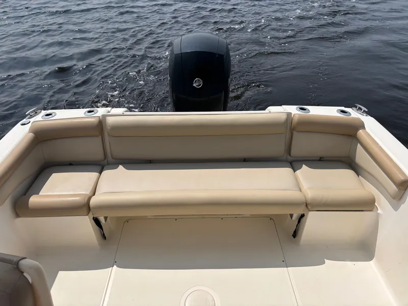 Slide: The Image of 2022 Scout 210 Dorado boat with beige seating and outboard motor on water. - 19