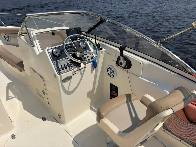 Slide: The Image of 2022 Scout 210 Dorado boat interior with steering wheel and controls on water. - 23