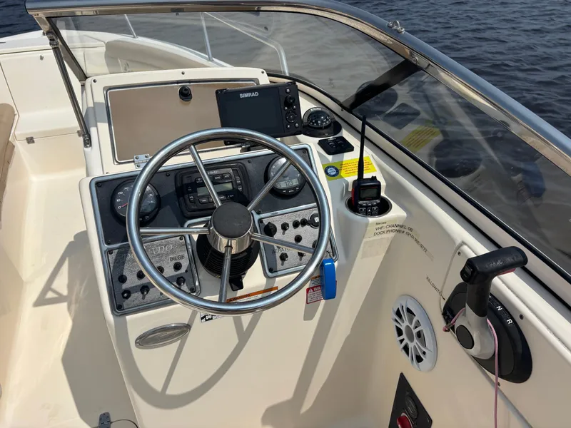 Slide: The Image of 2022 Scout 210 Dorado boat dashboard with steering wheel and navigation controls. - 26