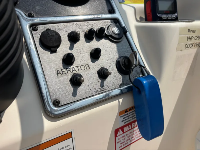 Slide: The Image of Control panel of a 2022 Scout 210 Dorado boat with switches and key. - 29