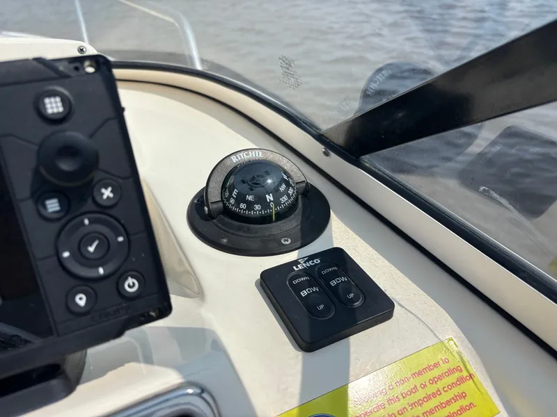 Slide: The Image of Control panel of 2022 Scout 210 Dorado boat with compass and trim tab switches. - 34
