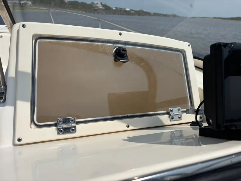 Slide: The Image of 2022 Scout 210 Dorado boat dashboard with closed compartment and electronic device. - 35