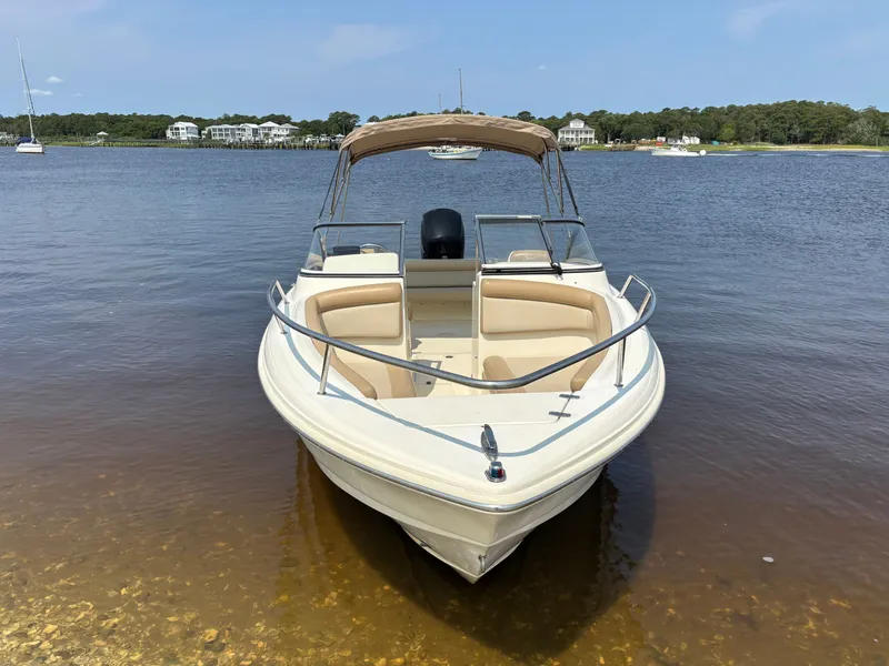Slide: The Image of 2022 Scout 210 Dorado boat docked on calm water with scenic background. - 8