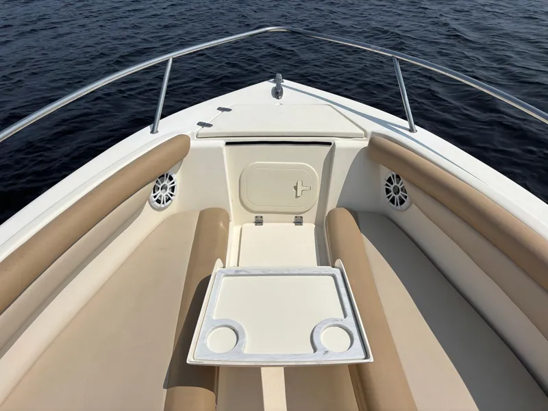Slide: The Image of 2022 Scout 210 Dorado boat interior with beige seating and table on calm water. - 9
