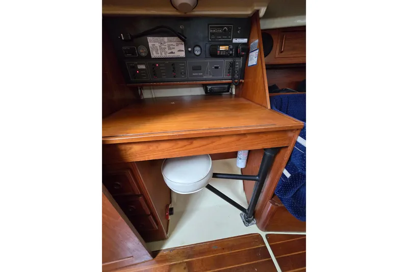 Slide: The Image of Interior of 1988 Pearson 362 Centerboard sailboat with blue cushioned seating and wooden table. - 12