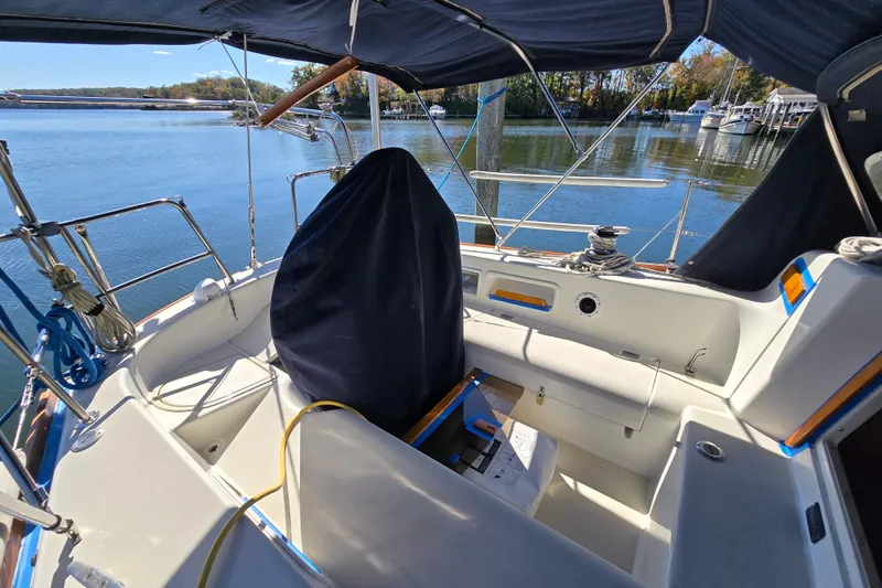 Slide: The Image of 1988 Pearson 362 Centerboard sailboat cockpit with covered wheel, docked by calm waters. - 28