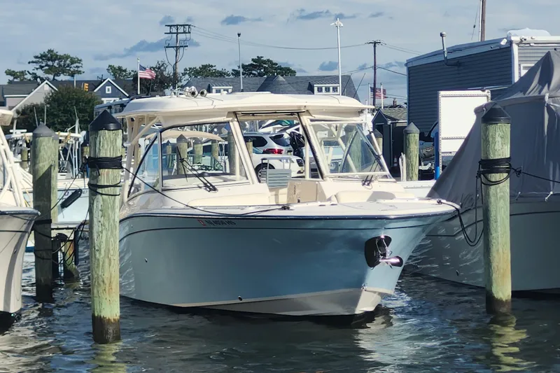 The Image of 2022 Grady-White Freedom 325 boat docked at a marina, surrounded by pilings. - 0