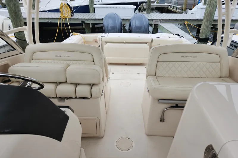 Slide: The Image of 2022 Grady-White Freedom 325 boat interior with luxurious seating and dual engines at dock. - 10