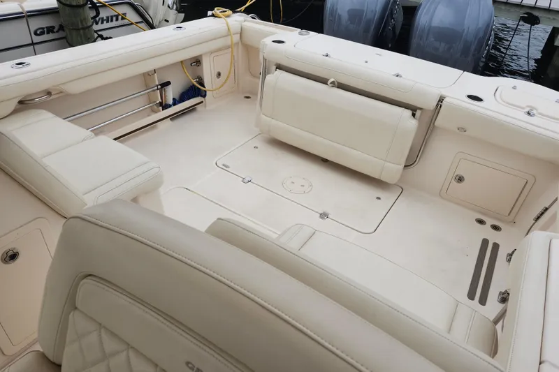 Slide: The Image of 2022 Grady-White Freedom 325 boat interior with beige seating and storage compartments. - 12