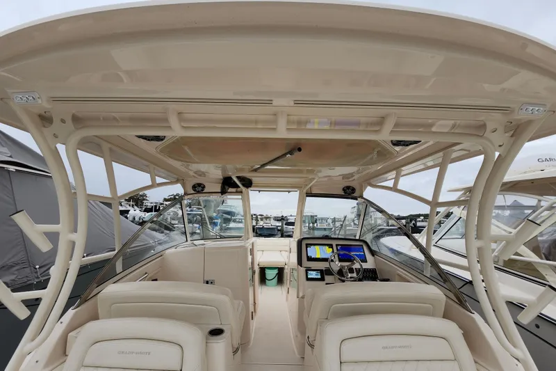 Slide: The Image of 2022 Grady-White Freedom 325 boat interior with helm and seating, docked at marina. - 14