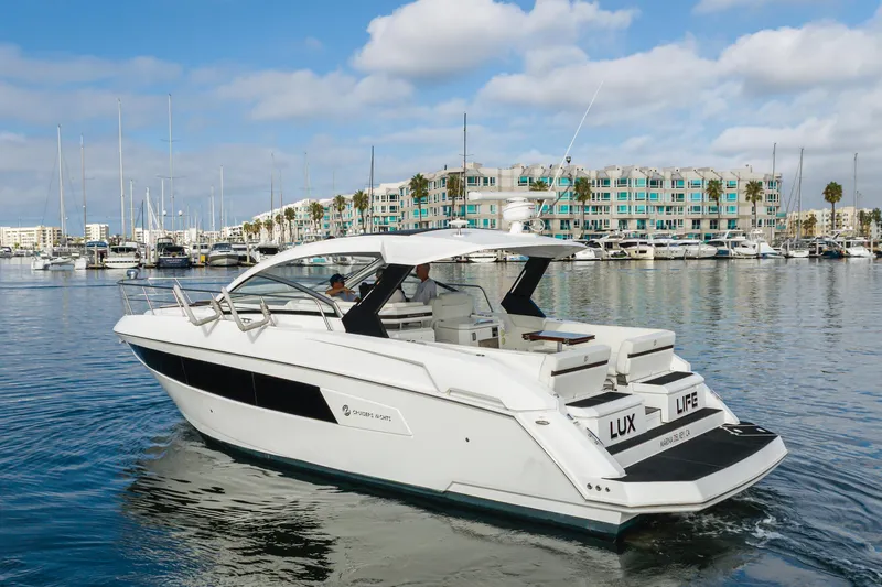 Slide: The Image of 2017 Cruisers Yachts 39 Express Coupe in marina, clear sky, modern waterfront buildings. - 14