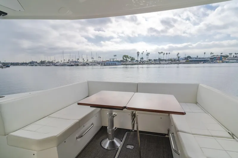 Slide: The Image of 2017 Cruisers Yachts 39 Express Coupe interior with seating and table, overlooking marina. - 25