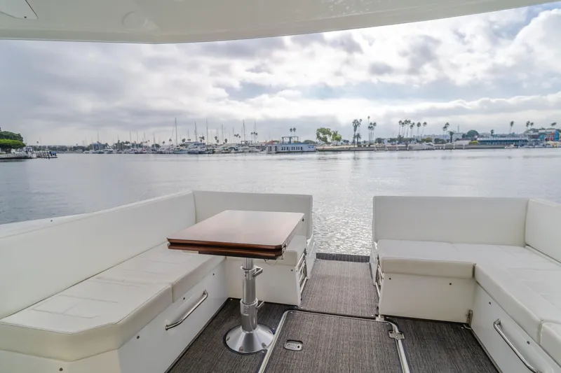 Slide: The Image of 2017 Cruisers Yachts 39 Express Coupe interior with waterfront view, featuring white seating and table. - 26