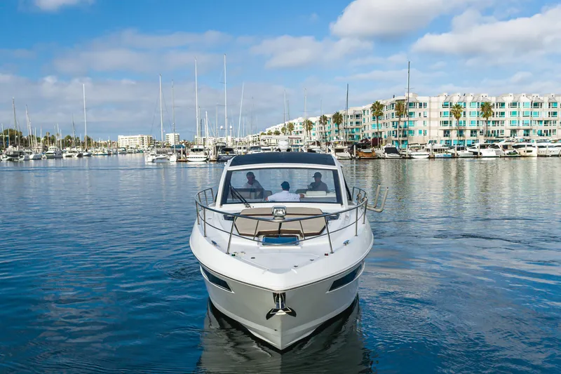 Slide: The Image of 2017 Cruisers Yachts 39 Express Coupe in marina, clear sky, waterfront buildings. - 9