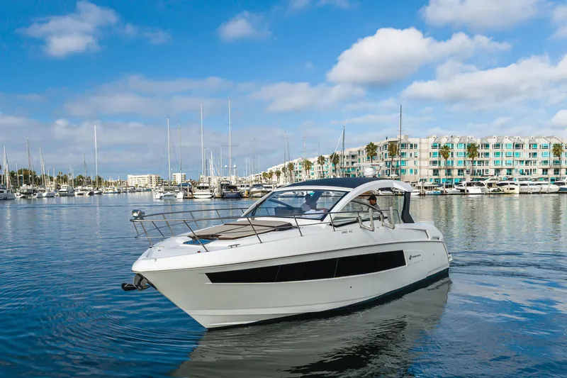 Slide: The Image of 2017 Cruisers Yachts 39 Express Coupe in a marina, clear sky, modern buildings. - 11