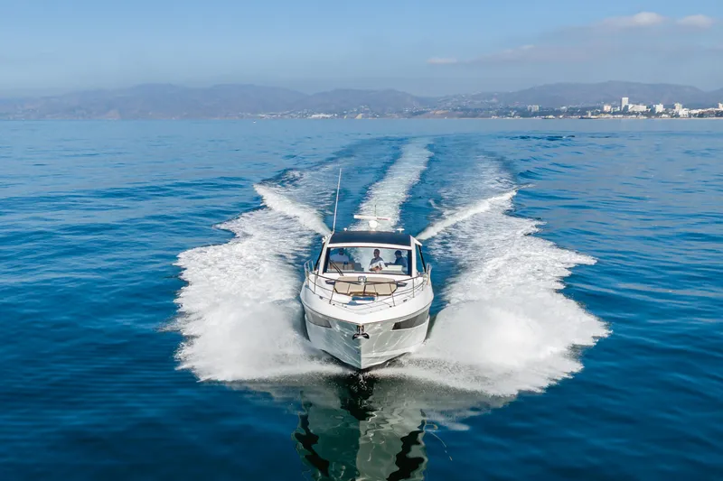 Slide: The Image of 2017 Cruisers Yachts 39 Express Coupe cruising on open water, scenic coastal backdrop. - 3