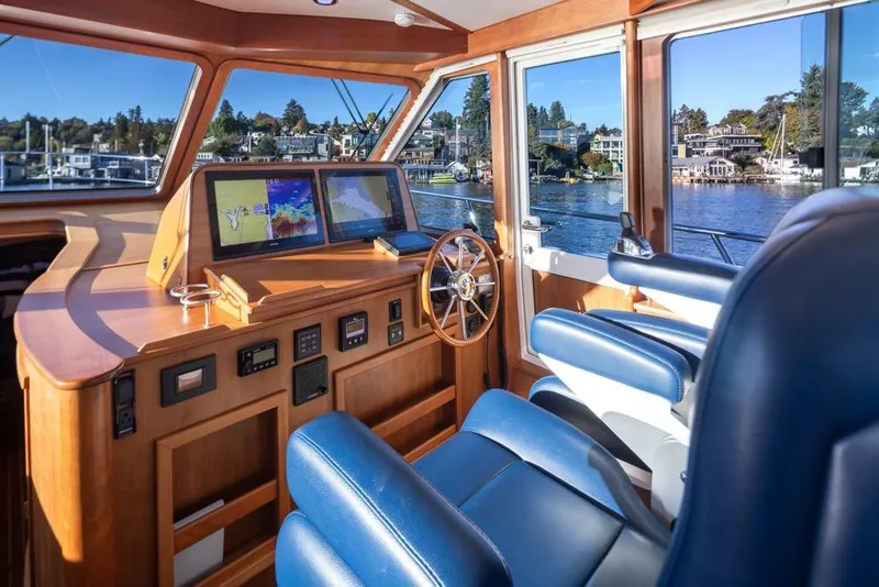 Slide: The Image of 2020 Sabre 45 Salon Express yacht interior with navigation screens and blue seating. - 21