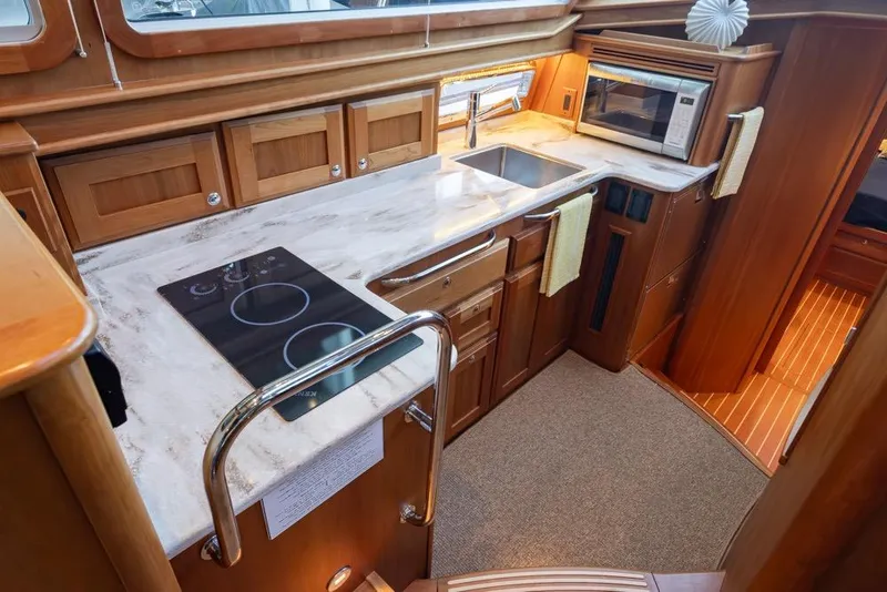 Slide: The Image of Luxurious 2020 Sabre 45 Salon Express yacht kitchen with modern appliances and elegant wood cabinetry. - 23