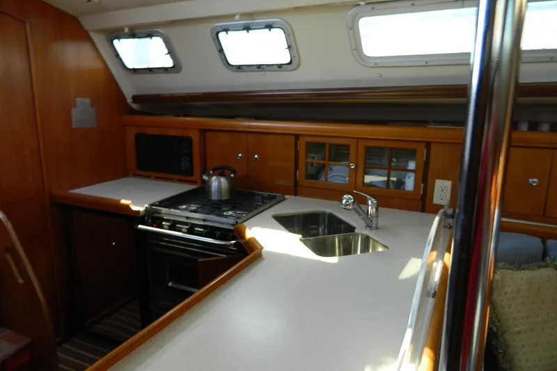 Slide: The Image of Interior of 2007 Hunter 41 AC sailboat kitchen with stove, sink, and wooden cabinetry. - 18