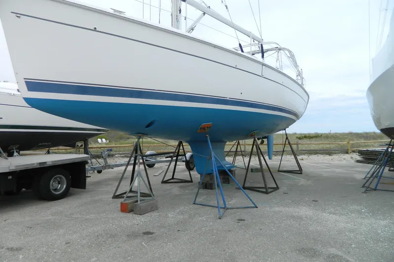 Slide: The Image of 2007 Hunter 41 Aft Cockpit sailboat on stands, blue hull, outdoor storage. - 33